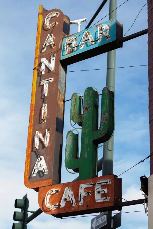 an old building with a neon sign and a cactus on top