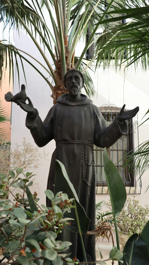 a statue of a man holding a small piece of silverware in one hand