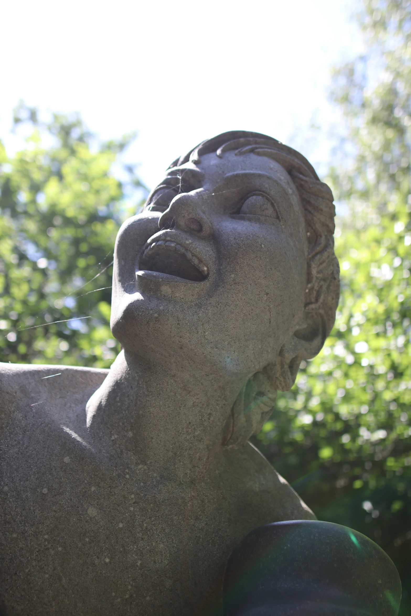 a small statue with trees in the background