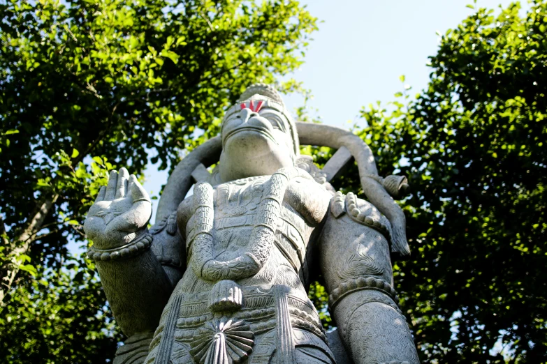 a statue holding an elephant is surrounded by trees