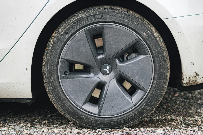 a car tire sits on a street covered in mud