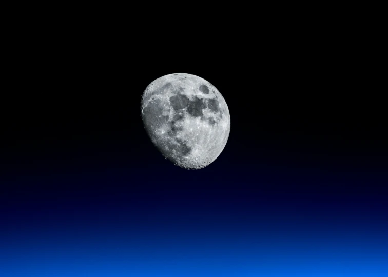 a po of the moon with dark sky and clouds in background