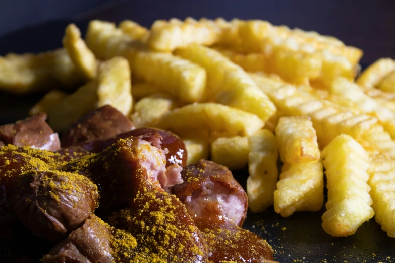 a pile of fried food next to fries with seasoning