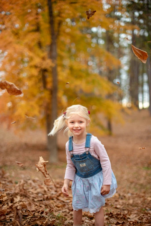  playing with falling leaves in the woods