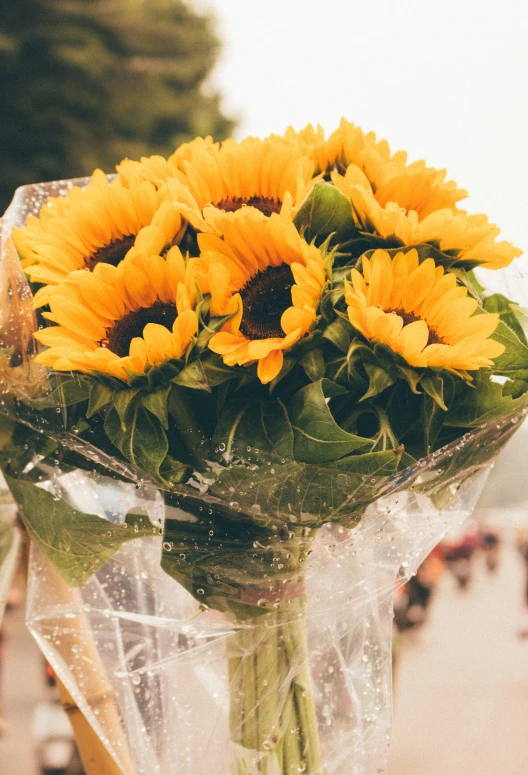 some yellow flowers sitting in a vase by a building