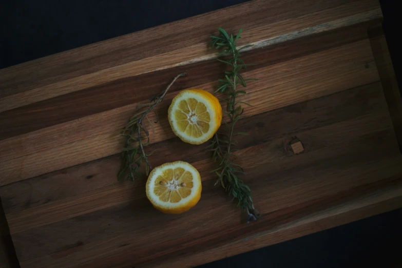 some lemons with herbs are on a  board