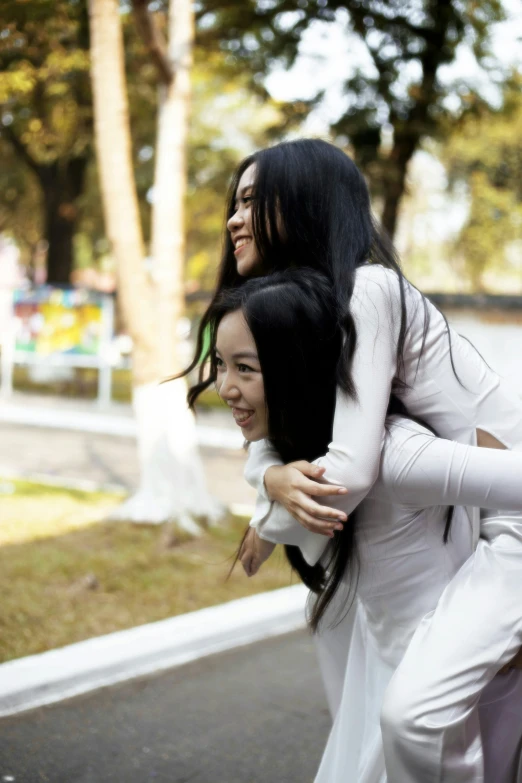 two young women walking down the street on top of each other