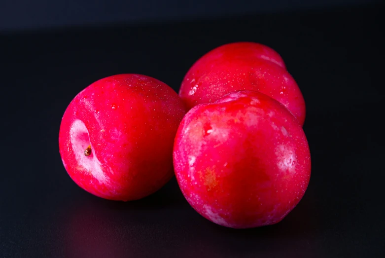 some red fruit sitting on a black table