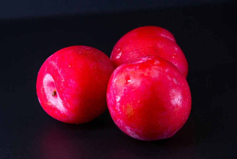 some red fruit sitting on a black table