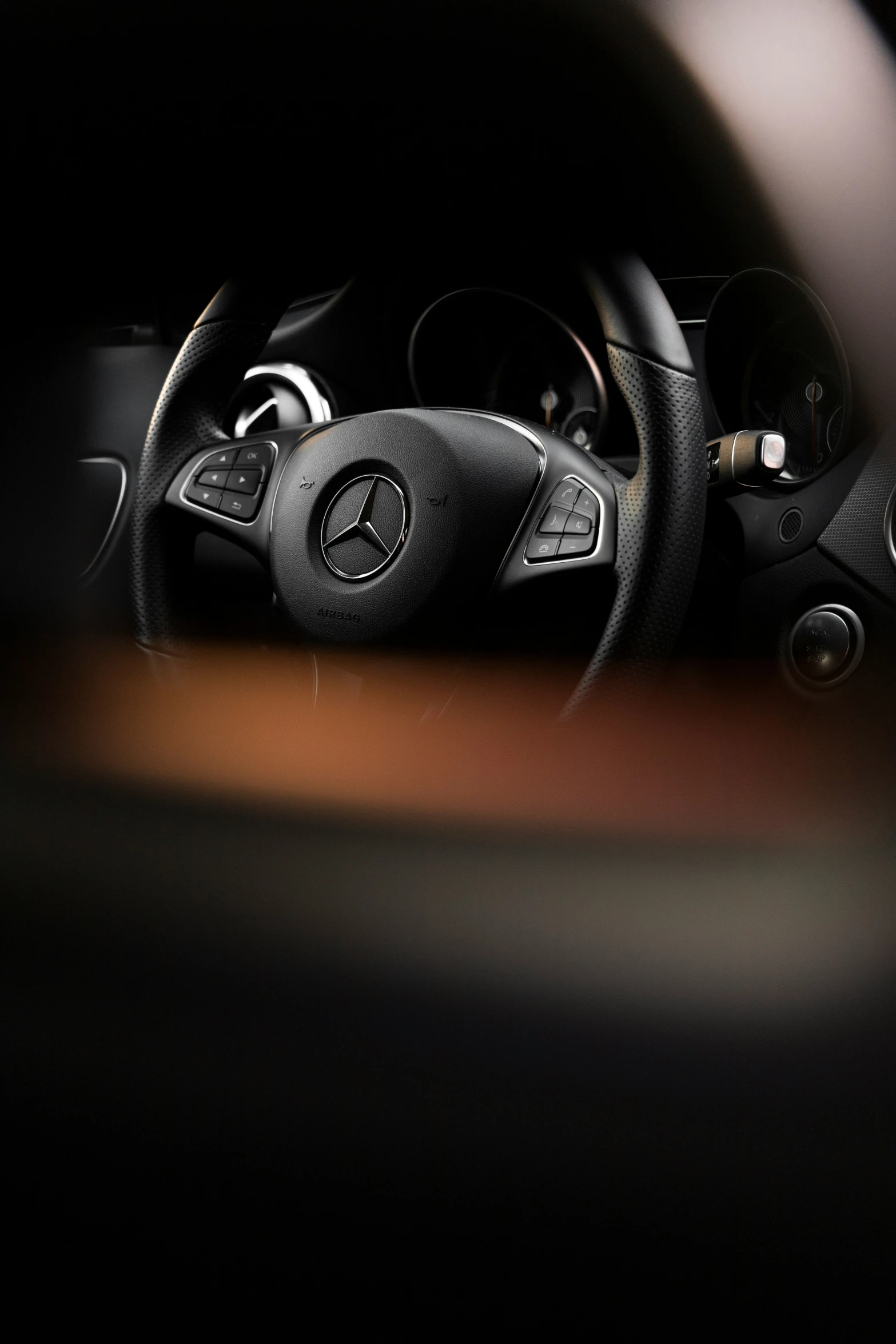 the steering wheel of a mercedes car in black