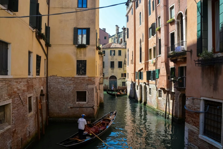 a gondola is in between buildings along an alley way