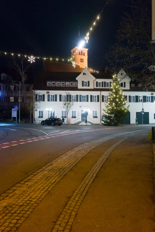 a town square has a building lit up at night