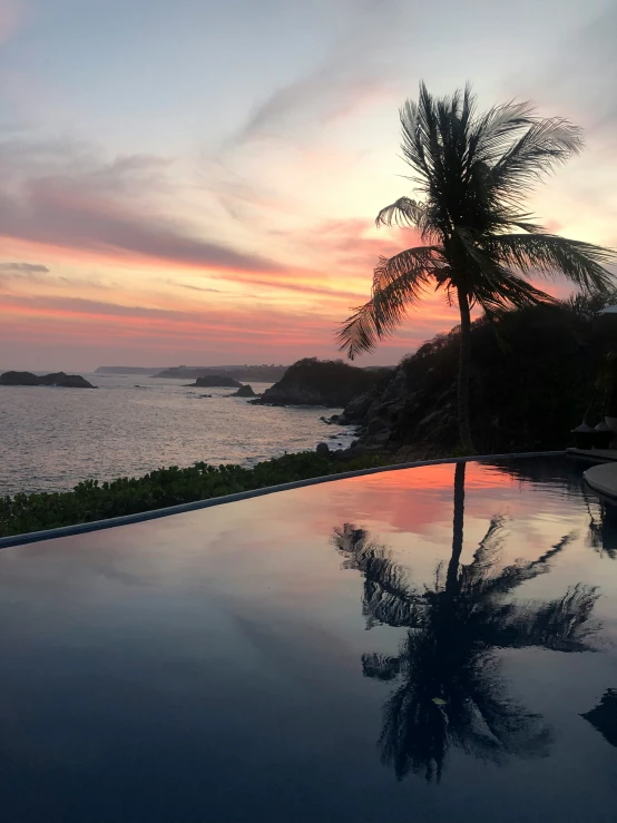 a pool with the ocean and sky in the background