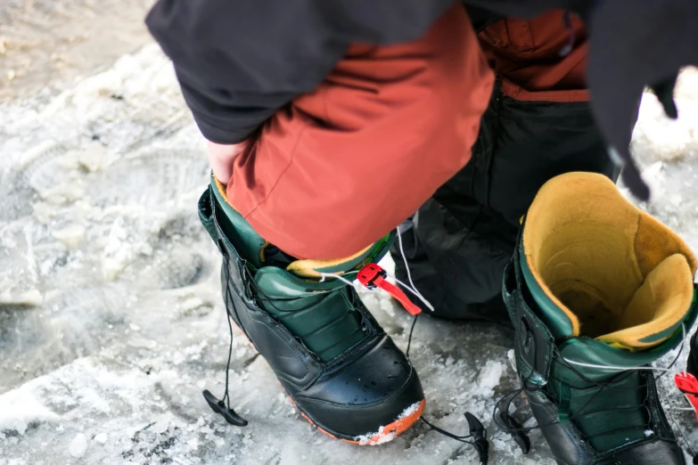 a persons feet and boot wearing snow shoes in some ice