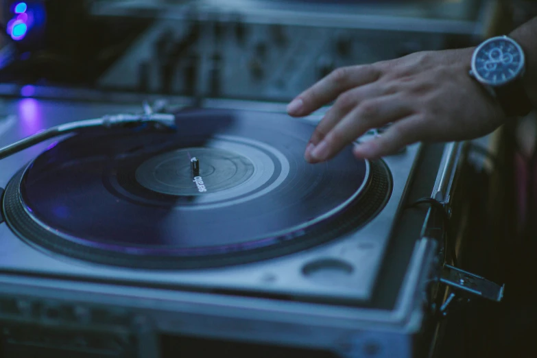 a hand that is on top of a record player