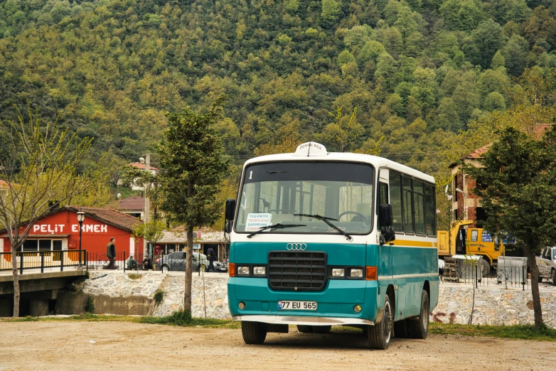 a small bus parked next to a lake