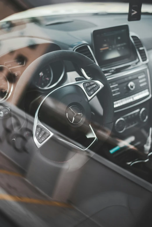 the inside view of a vehicle, which includes the steering wheel and control on