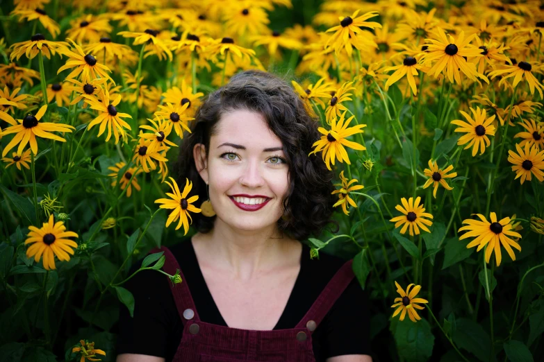 a woman smiling in a field of yellow flowers