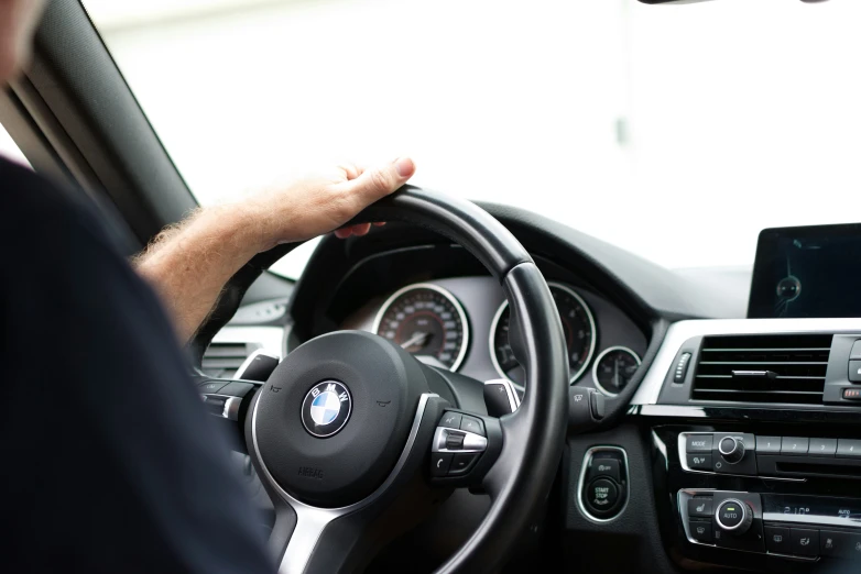 person driving a vehicle while holding the steering wheel