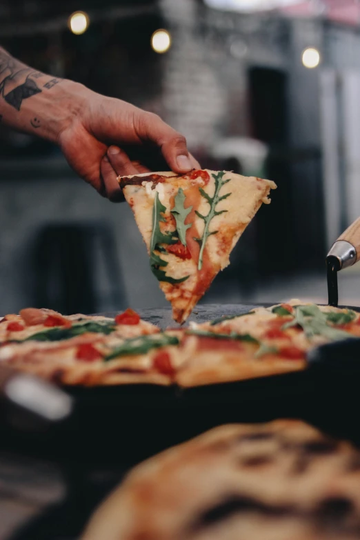 a man taking a slice of cheese pizza from a plate