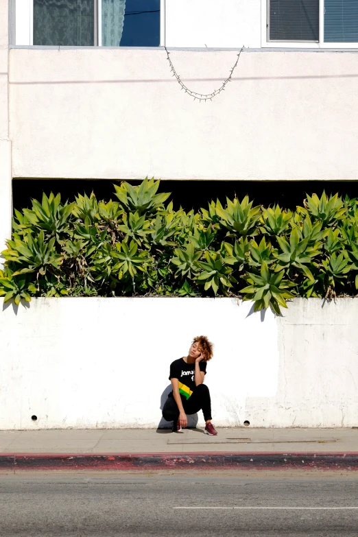 a person kneeling in front of a potted plant