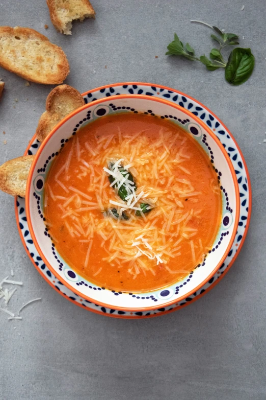 a bowl of soup, with bread on the side