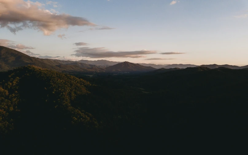 a lone airplane is seen above a mountain range