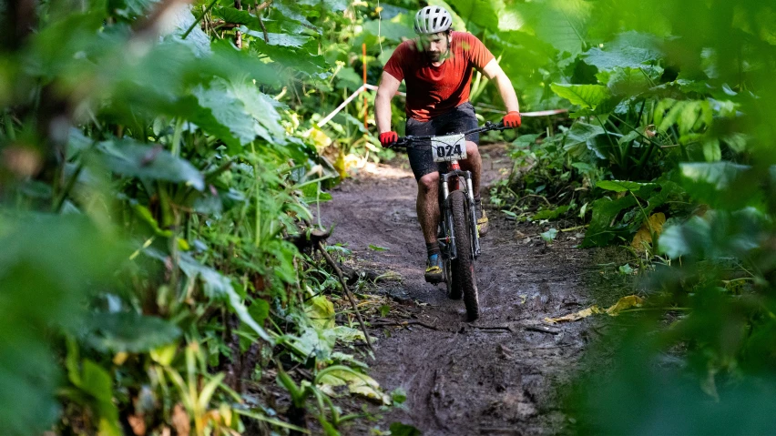 a man is riding on a trail in the woods