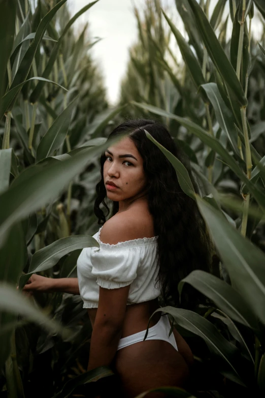 a beautiful young lady sitting in the middle of some grass