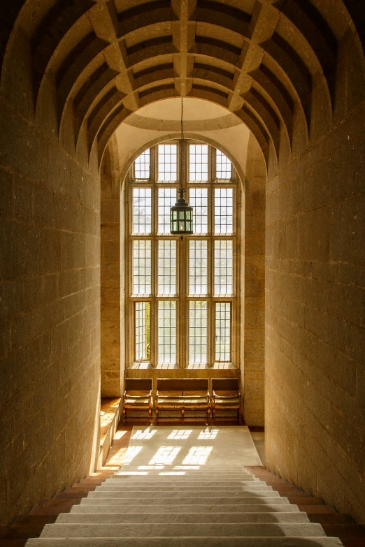 a view looking into a small room that has two windows and bench in front of it