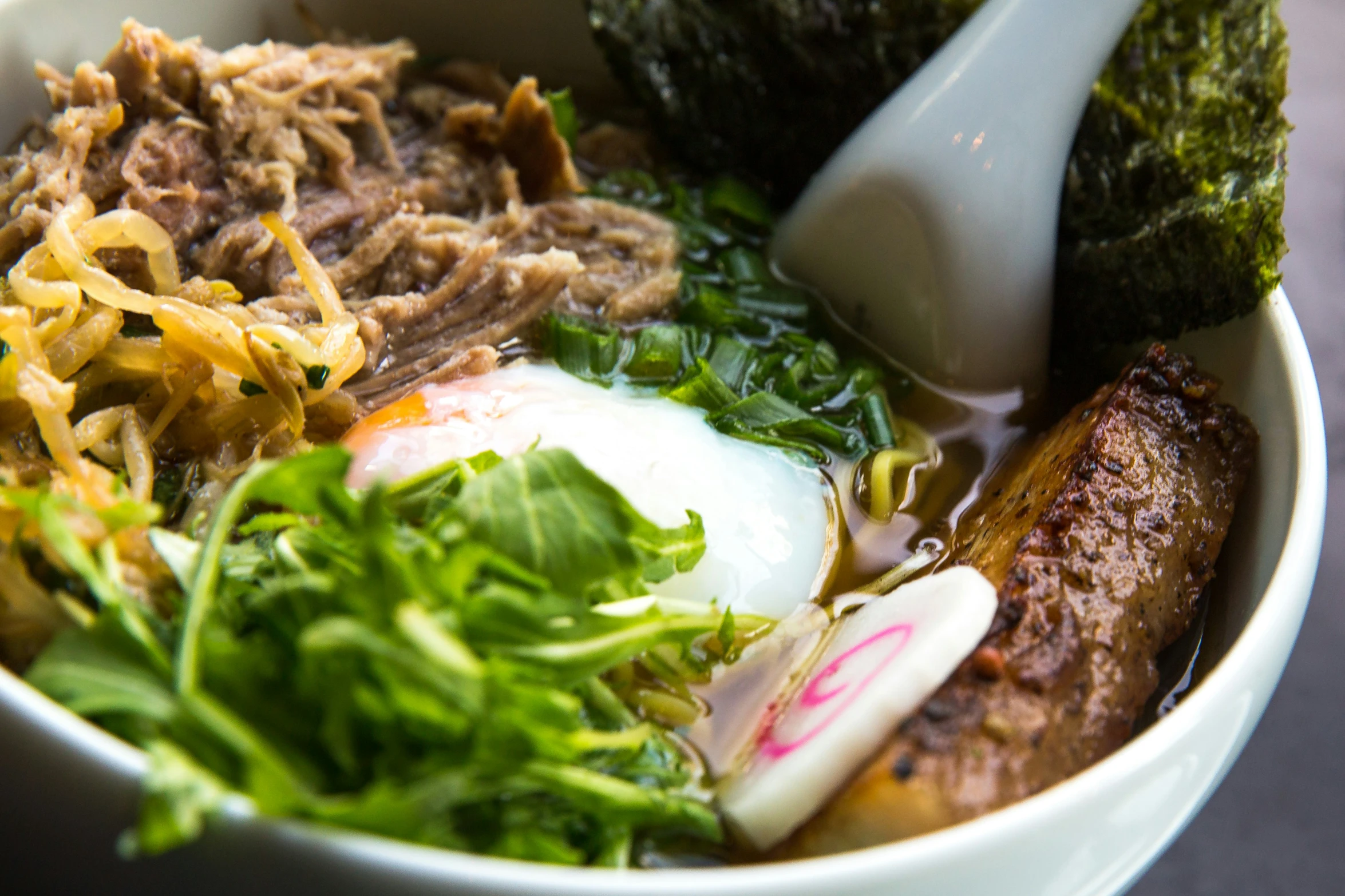 a bowl of meat and vegetables sitting on a table