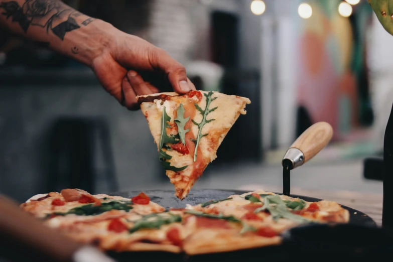 a man putting toppings on slices of pizza