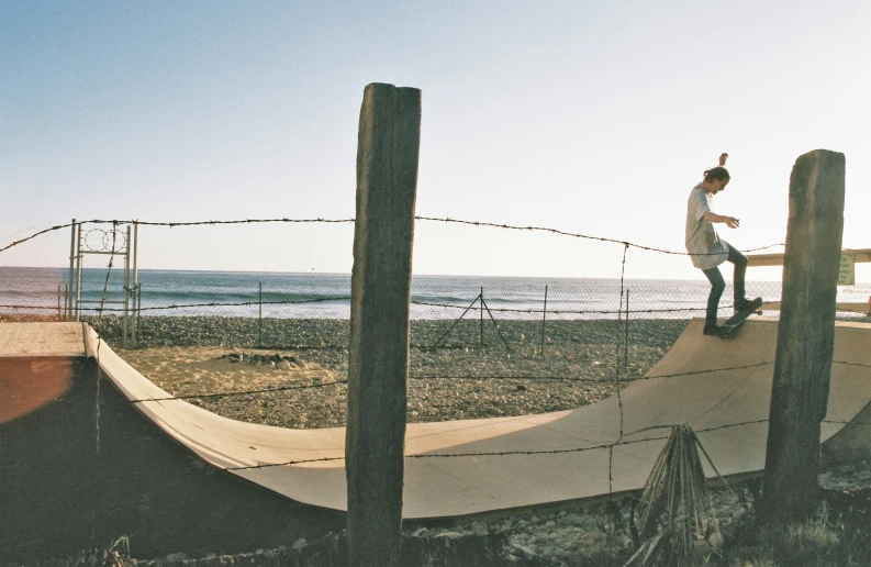 a man skateboards on a ramp in front of the water