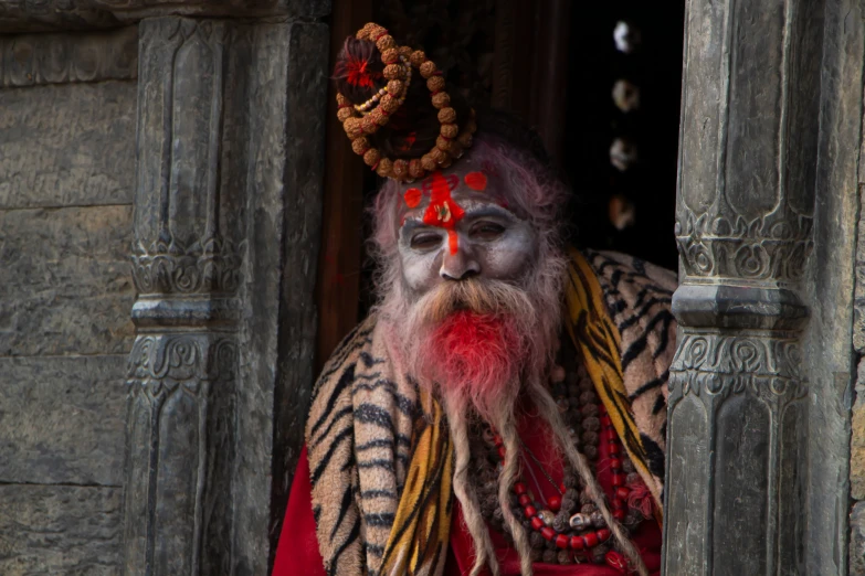 an old man with a white beard and red make - up