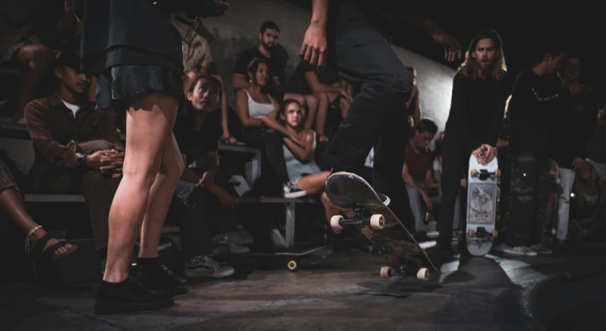 people watching a skateboarder do a trick on his board