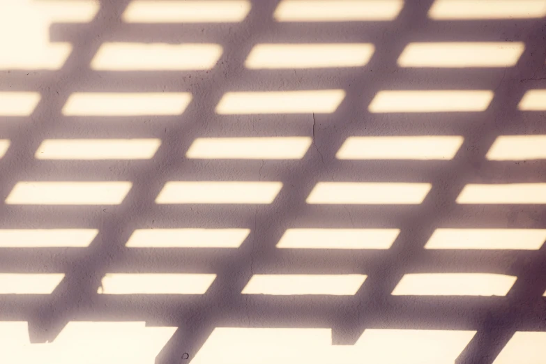 the shadow of a fence with a umbrella