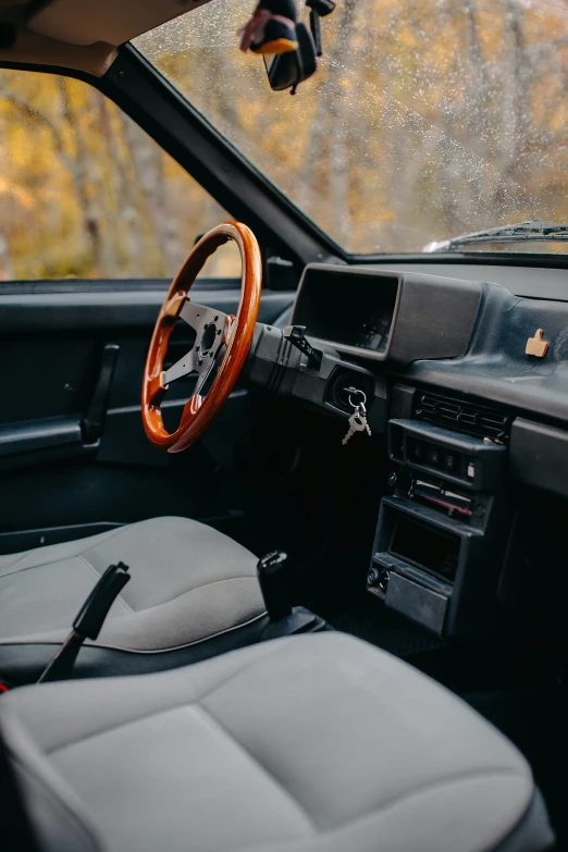 a car interior with dashboard, steering wheel, and dashboard with wood trim