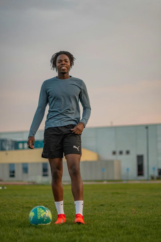 a man standing next to a ball on a field