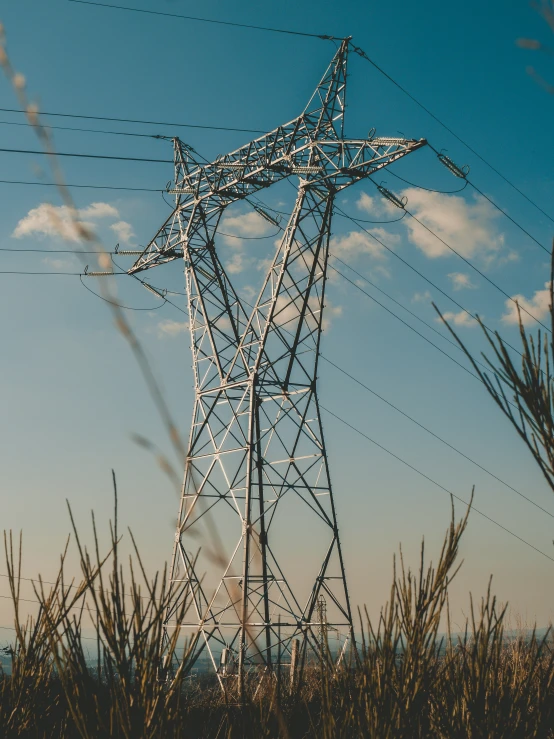 an electric pole standing in the middle of a field