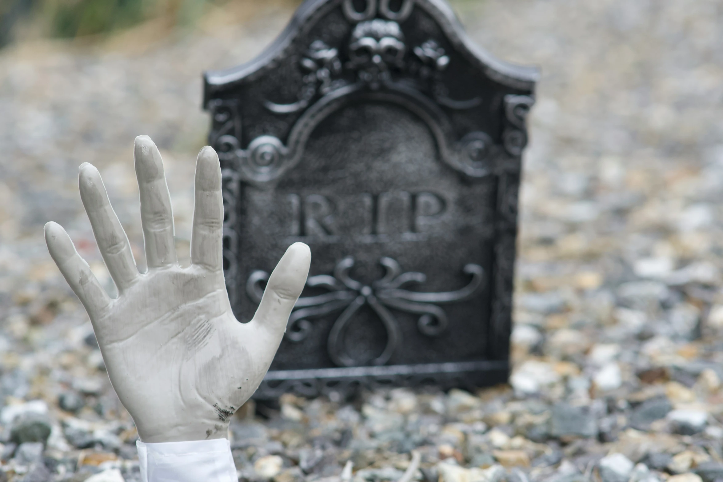 someone with their hand out in front of a gravestone