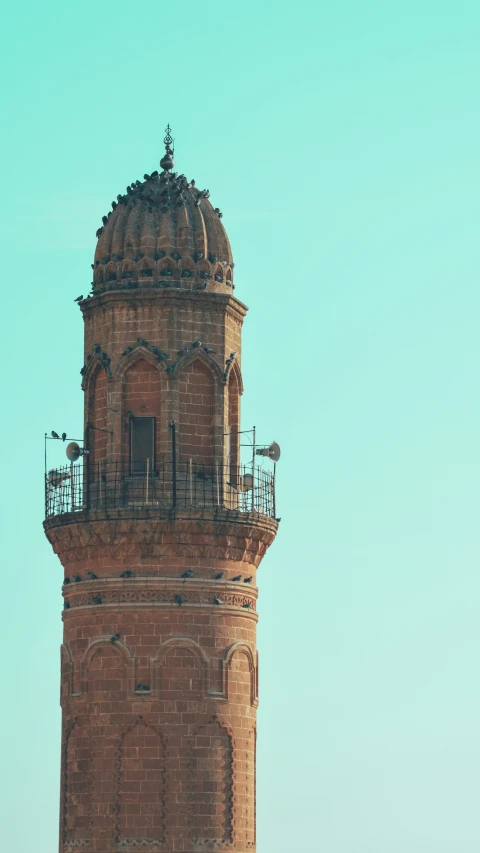 a very tall brick tower with a small bell on top