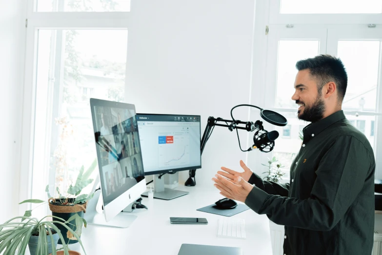 a man talking on a computer screen in front of a microphone