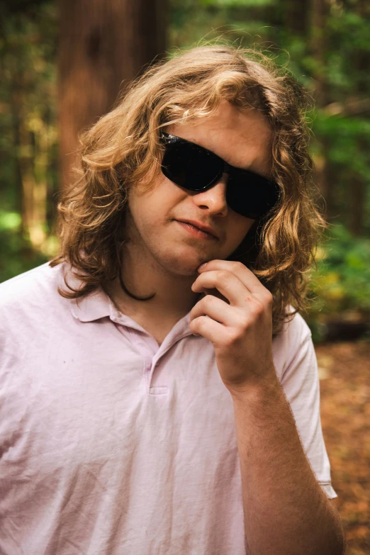 a man with sunglasses on wearing a pink shirt