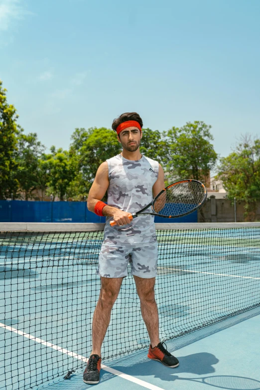 a man with tennis racket on a blue court