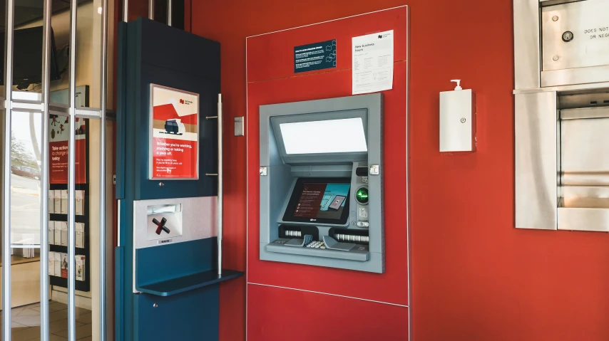 a red and blue wall with an atm machine