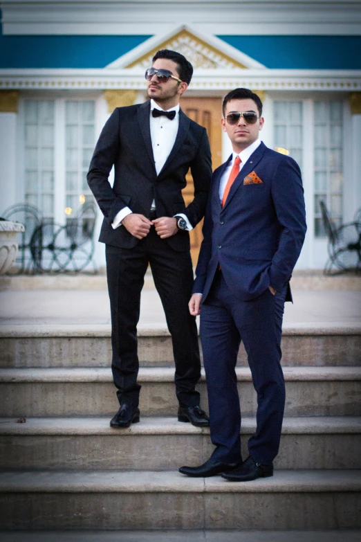 two men in suits standing outside a building