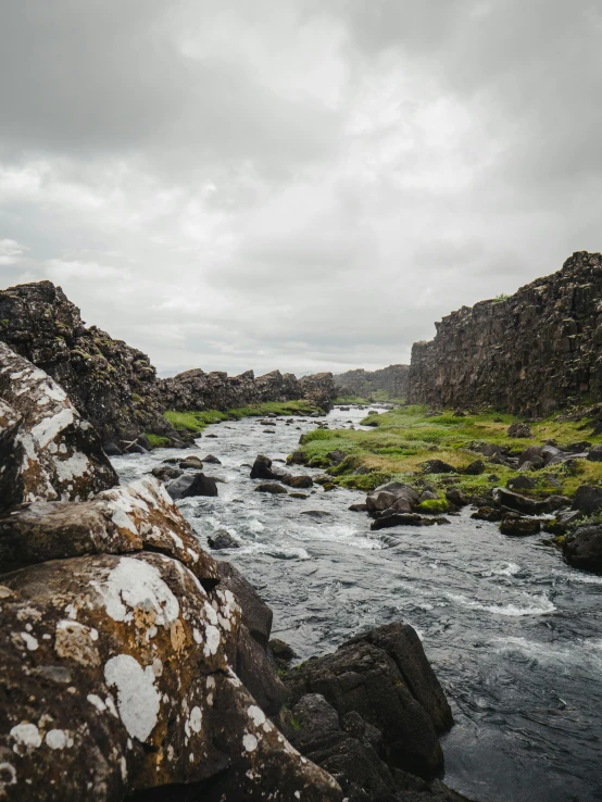 a stream running through a valley with rocks