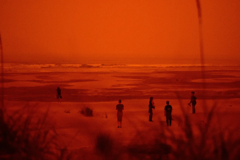 people are in the sand with orange light