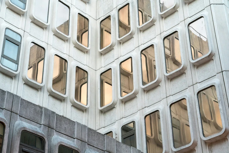 a tall building with windows reflecting the sky