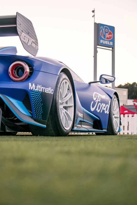 the front view of a blue sports car parked in the grass